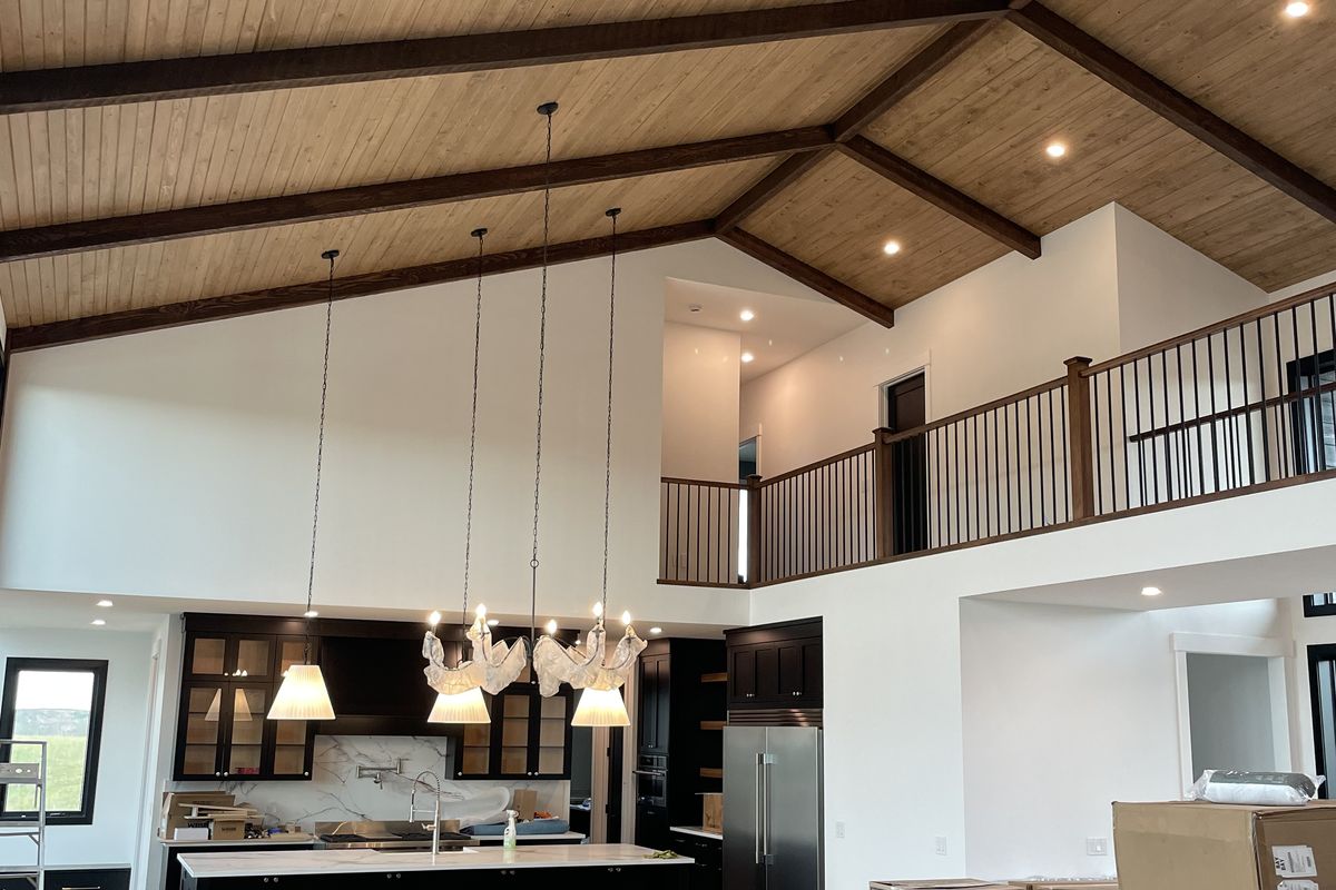 Vaulted great room with wood-beam ceiling wired by Taiga Electric